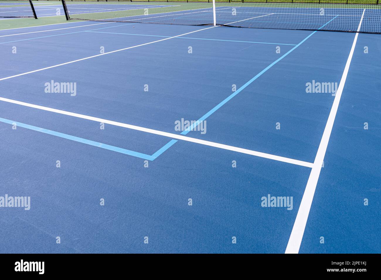 Photo en gros plan du nouveau court de tennis bleu extérieur avec lignes de pickleball bleu clair. Banque D'Images