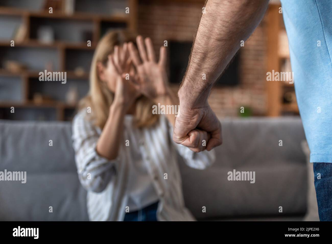 Triste pleurs adulte la femme caucasienne couvre son visage, peur de son mari agressif dans la salle de séjour à l'intérieur Banque D'Images