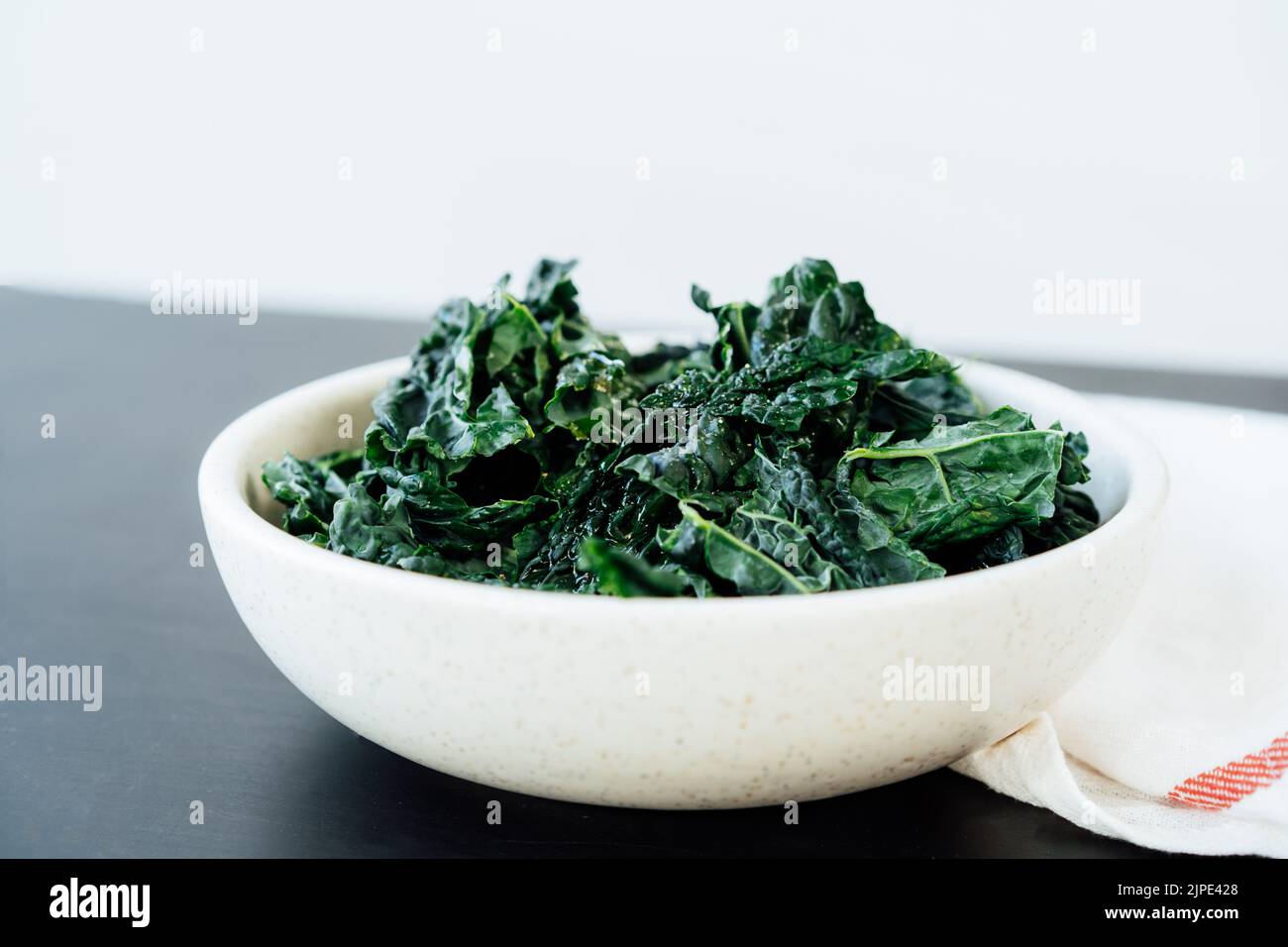 Des feuilles de chou vert poêlé dans l'assiette avec assaisonnements et huile d'olive sur la table de cuisine. Ingrédients pour des chips de chou frisé ou un repas de salade sain. Réparer Banque D'Images Des feuilles de chou vert poêlé dans l'assiette avec assaisonnements et huile d'olive sur la table de cuisine. Ingrédients pour des chips de chou frisé ou un repas de salade sain. Réparer Banque D'Images