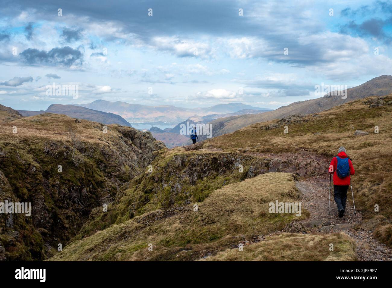 Deux marcheurs approchant Ruddy Gill d'Esk Hause avec Derwent Water au loin, Lake District National Park, Cumbria, UK paysages Banque D'Images