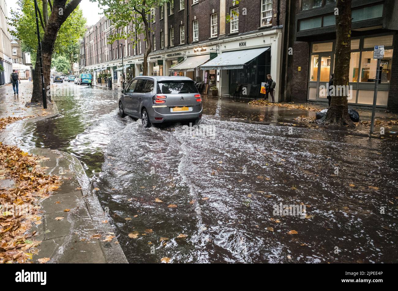 Une voiture traverse la rue Store Street inondée dans le centre de Londres après une pluie terrenversante, Angleterre, Royaume-Uni, Climate change. Banque D'Images