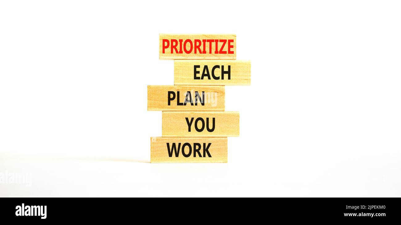 Donnez la priorité à chaque symbole de plan que vous travaillez. Les mots de concept donnent la priorité à chaque plan que vous travaillez sur des blocs de bois sur un magnifique fond blanc de table. Entreprise Banque D'Images