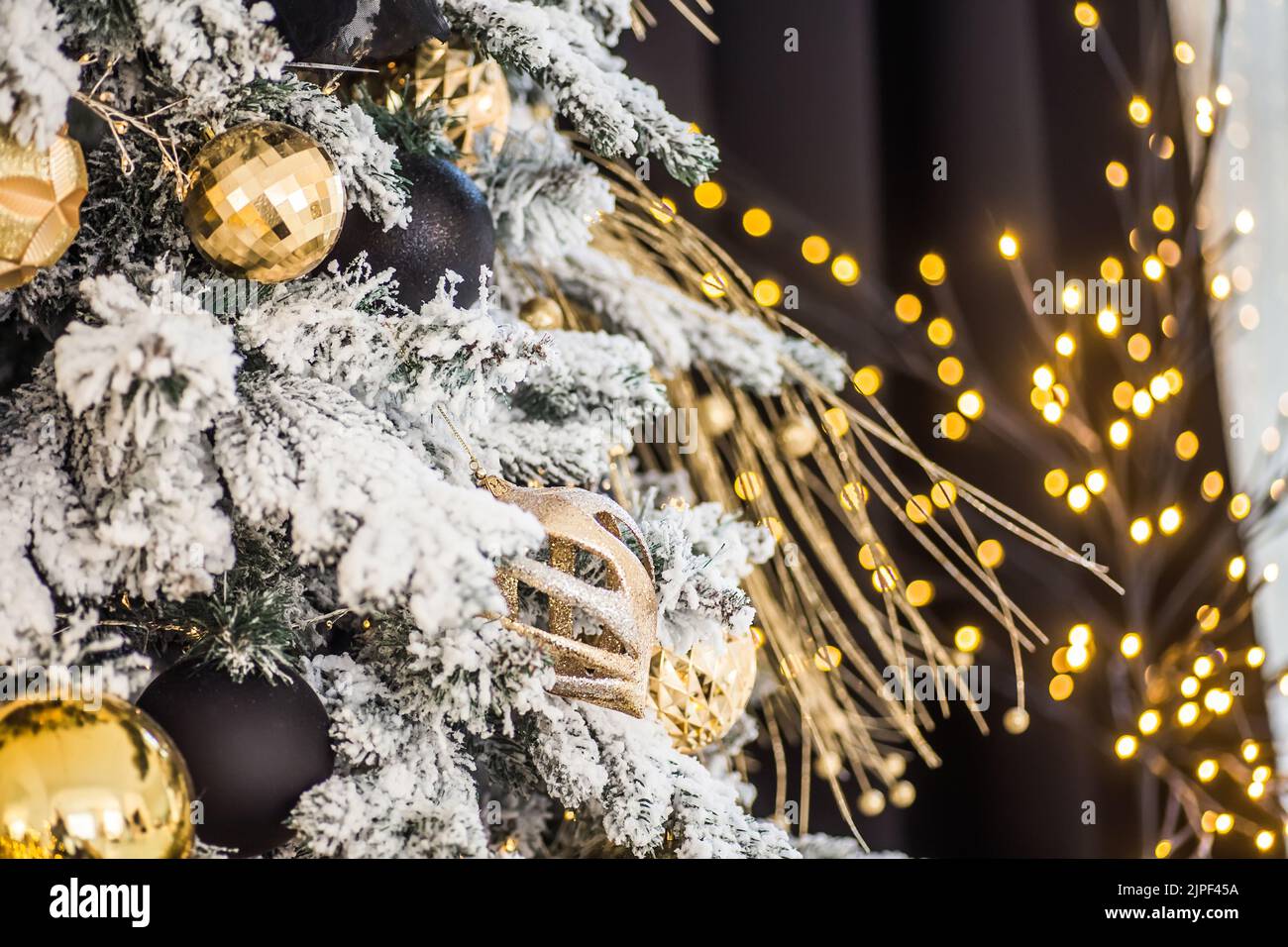 Arbre de Noël décoré de fleurs et d'oiseaux.Décorations originales sur les branches de l'arbre de Noël, concept du nouvel an.Guirlande de bokeh en arrière-plan Banque D'Images
