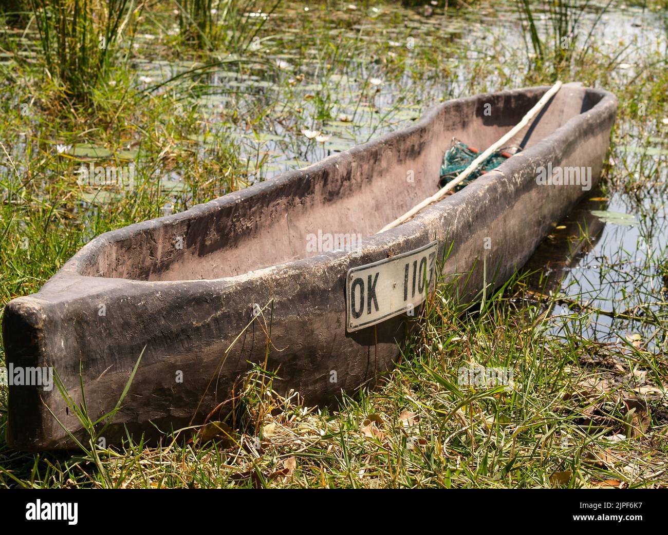 Botswana - 30 août 2007; pirogue traditionnelle tirée vers le haut jusqu'au bord. Dans le delta d'Okavango avec le nom et la plaque d'immatriculation sur le côté.lumière de la cuisine de la pièce allumée Banque D'Images