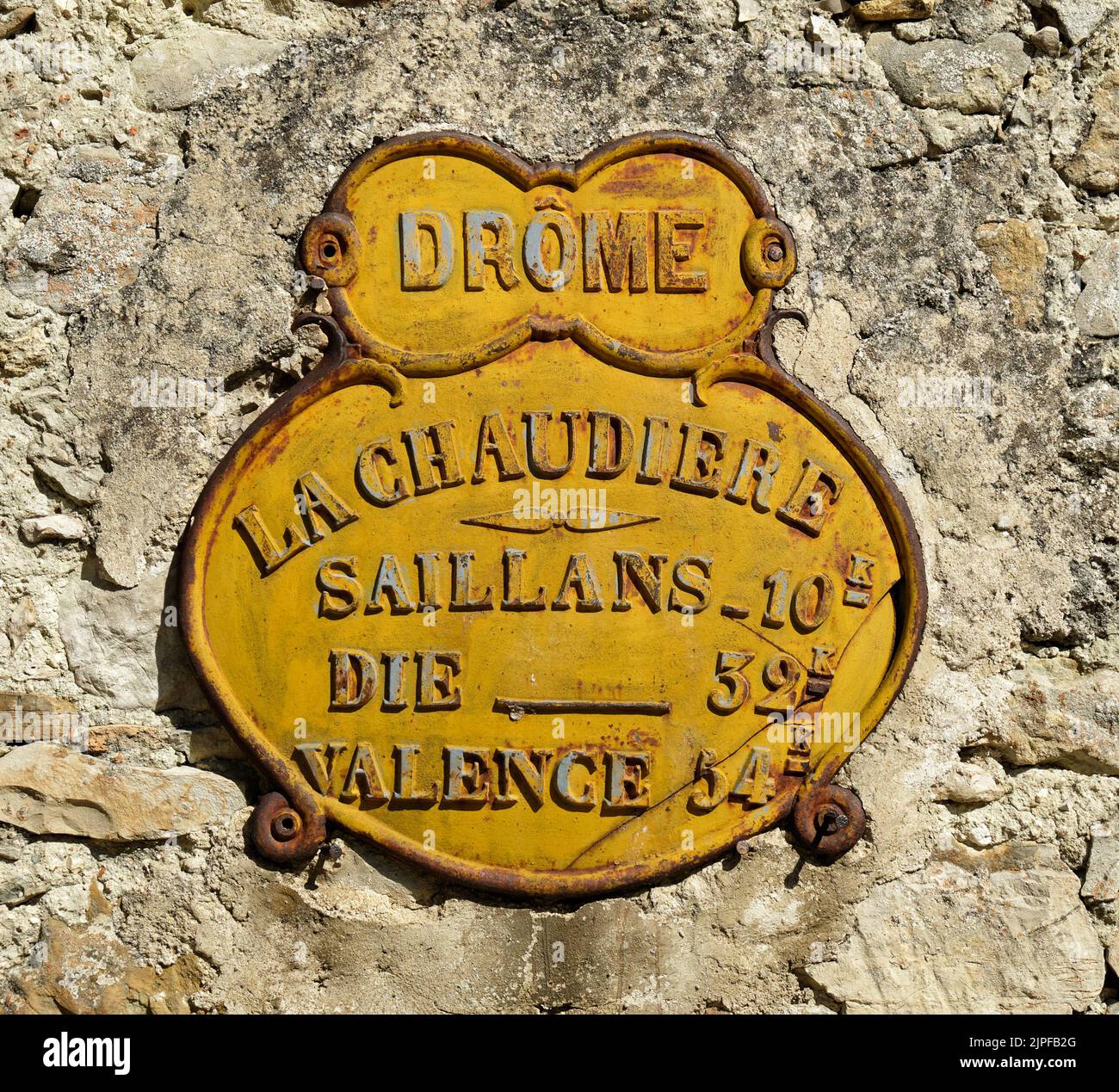 Vieux signe de distance sur un mur à la Chaudière dans le département de Drôme, montrant les distances à Saillans, Die et Valence. Banque D'Images