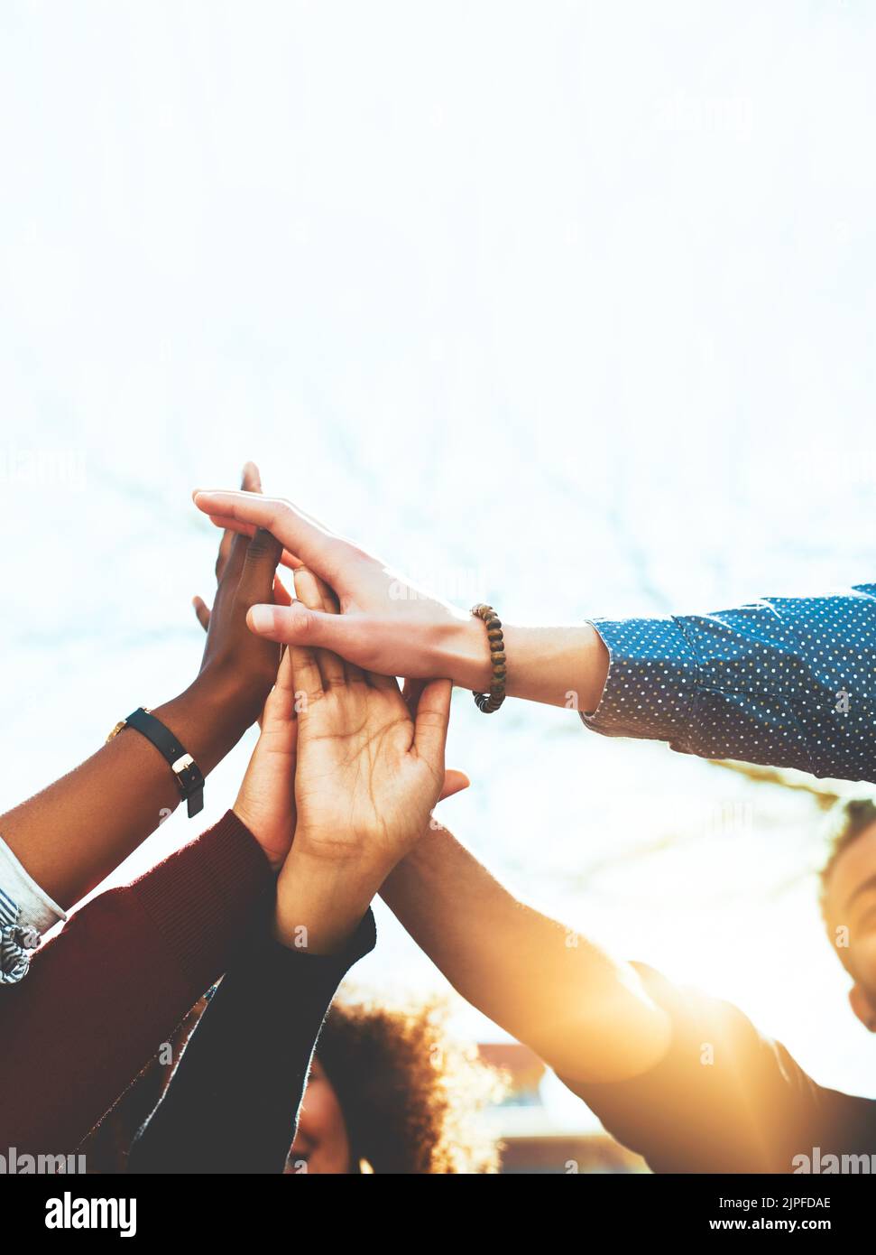 Faisons ceci. Un groupe méconnaissable d'amis d'université de haut fiving en se tenant dehors. Banque D'Images