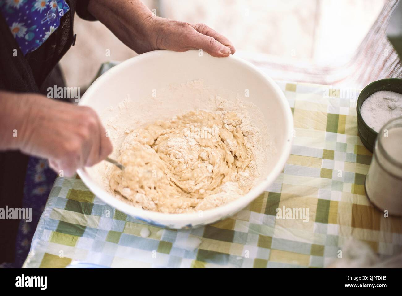 Grand-mère mélangeant la pâte pour crêpes Banque D'Images