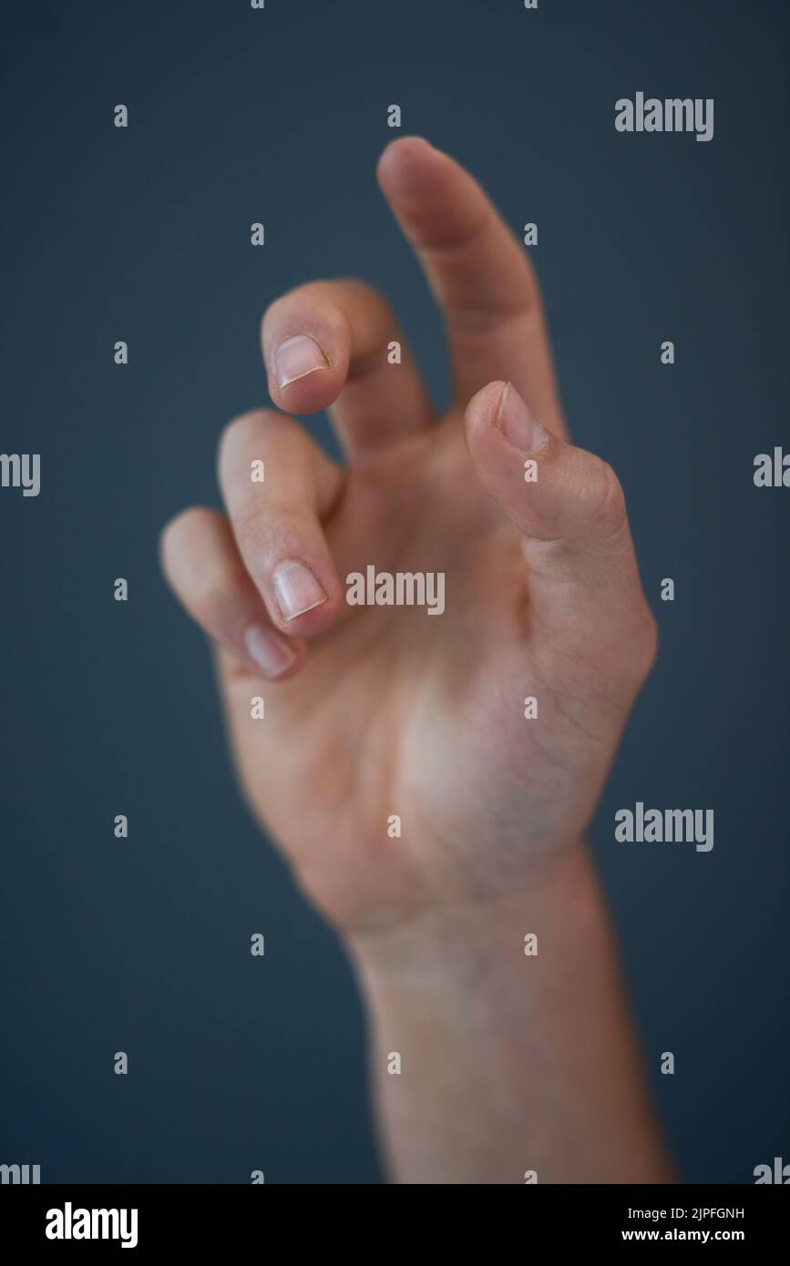Tendre la main. Photo en studio d'une main de homme méconnue sur fond bleu. Banque D'Images