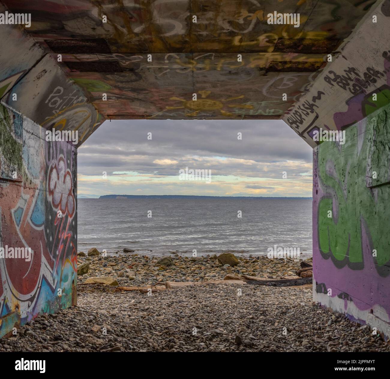 L'océan à travers un tunnel piétonnier rempli d'un mur de graffiti à White Rock, Canada Banque D'Images