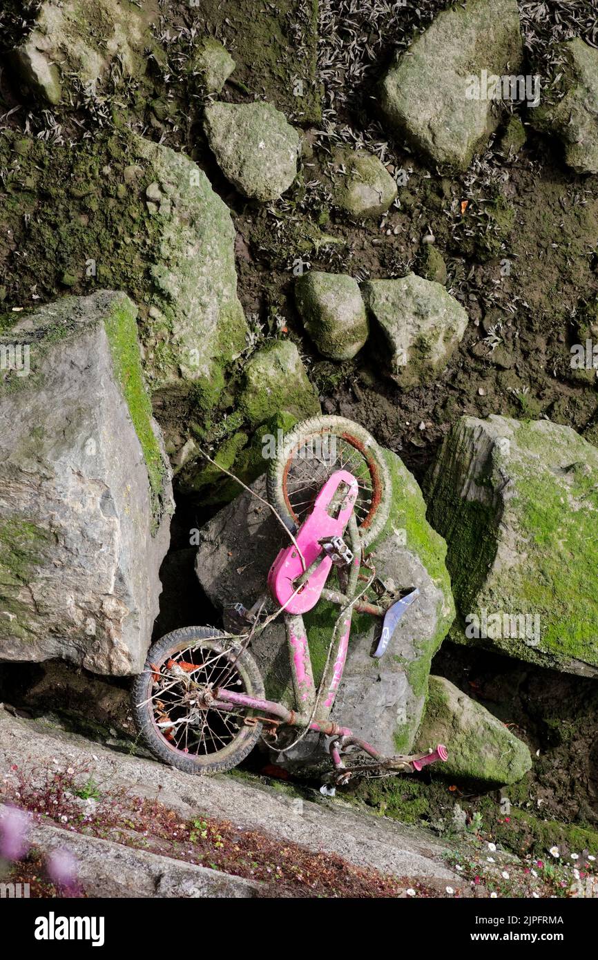 Plan vertical de la bicyclette pour enfants au fond de la rivière exposée à marée basse. Ancien vélo jeté. Déchets urbains. Vue de dessus. Banque D'Images