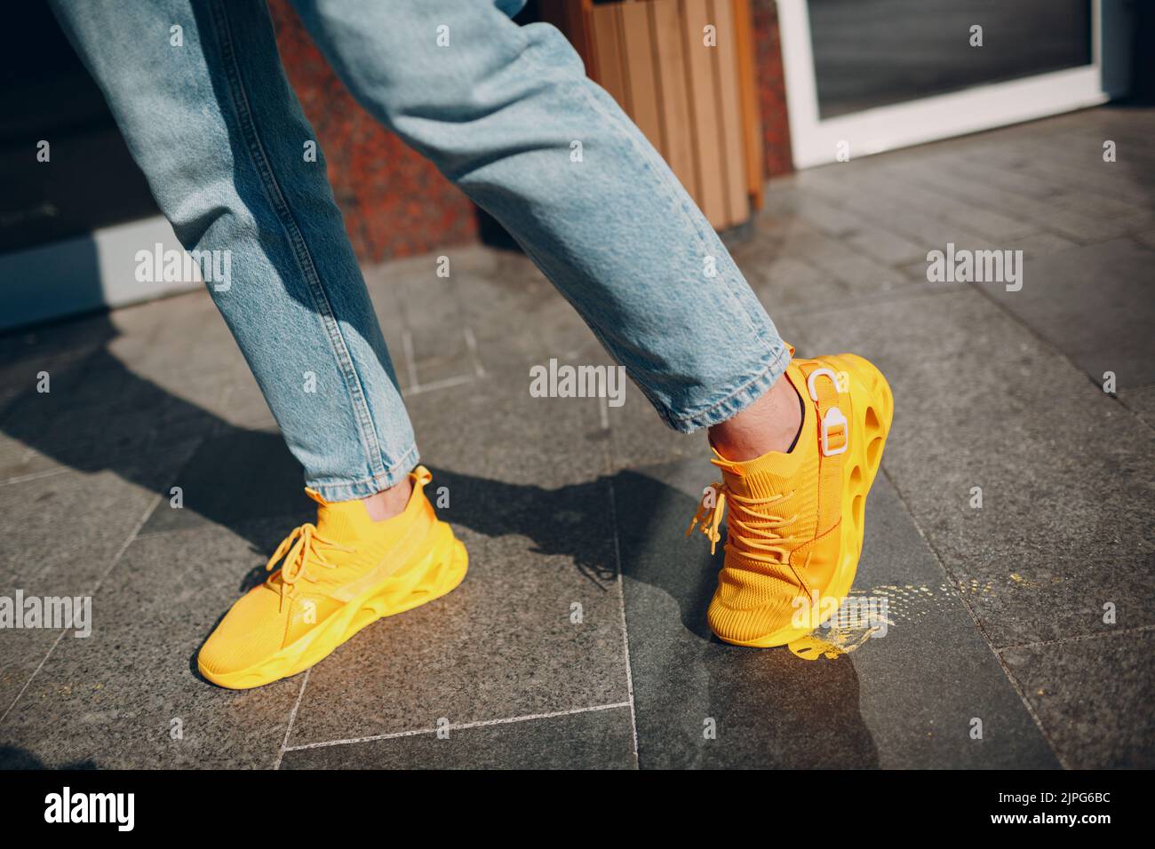 Chaussures jaunes Skechers homme étalées sur des traces de peinture jaunes Banque D'Images