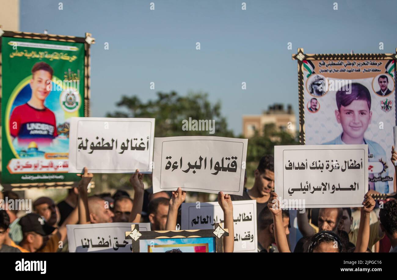 Les Palestiniens et les enfants tiennent des pancartes avec des messages et des photos des enfants tués, appelant à la protection des enfants lors d'une veillée sur le site où 5 enfants de la famille Najm ont été tués lors de la dernière attaque israélienne sur Gaza. Les Palestiniens tiennent une veillée au cimetière de Falloujah près du camp de réfugiés de Jabalia, dans le nord de la bande de Gaza. Cette veillée intervient à la suite de la reconnaissance par les autorités israéliennes du meurtre de cinq enfants dans une attaque aérienne israélienne sur le cimetière de Fallujah, à l'ouest du camp de réfugiés de Jabalia, dans le nord de la bande de Gaza. (Photo de Yousef Masoud/SOPA Images/Sipa US Banque D'Images