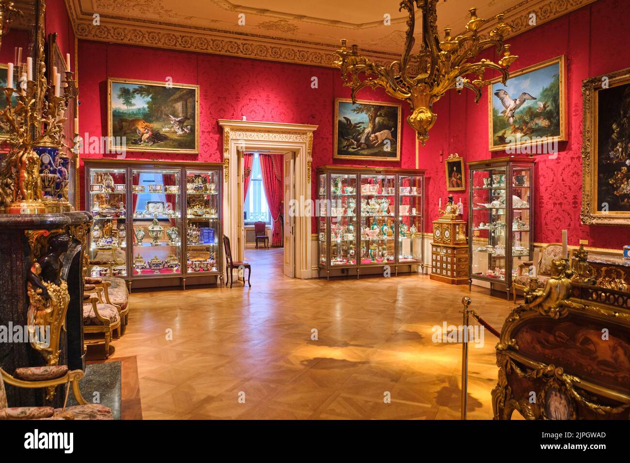 Une salle avec papier peint rouge et des armoires avec des collections de vaisselle de chine. Au Wallace Collection Museum de Londres, Angleterre, Royaume-Uni. Banque D'Images