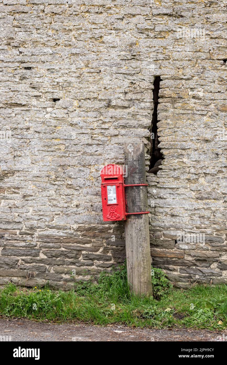 Boîte postale rurale du Royal Mail contre le vieux mur de la grange en pierre Banque D'Images