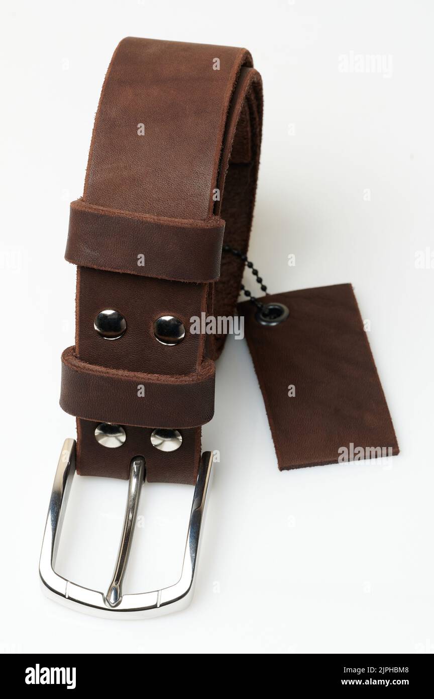 Ceinture roulée marron pour hommes avec étiquette isolée sur fond de studio Banque D'Images