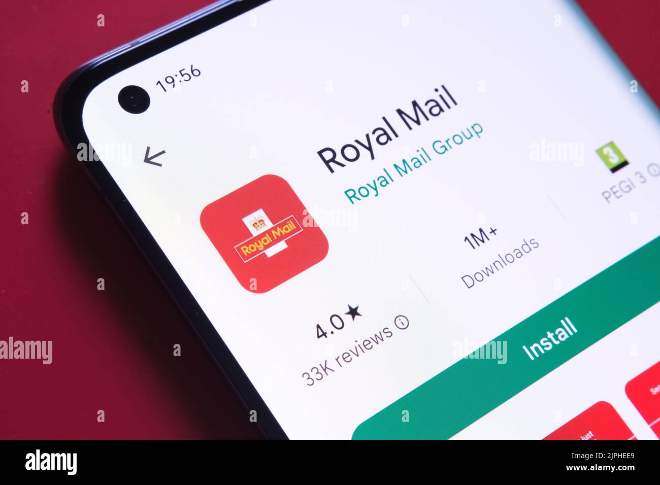 Application royal Mail vue dans Google Play Store sur l'écran du smartphone placé sur fond rouge. Gros plan avec mise au point sélective. Stafford, United King Banque D'Images