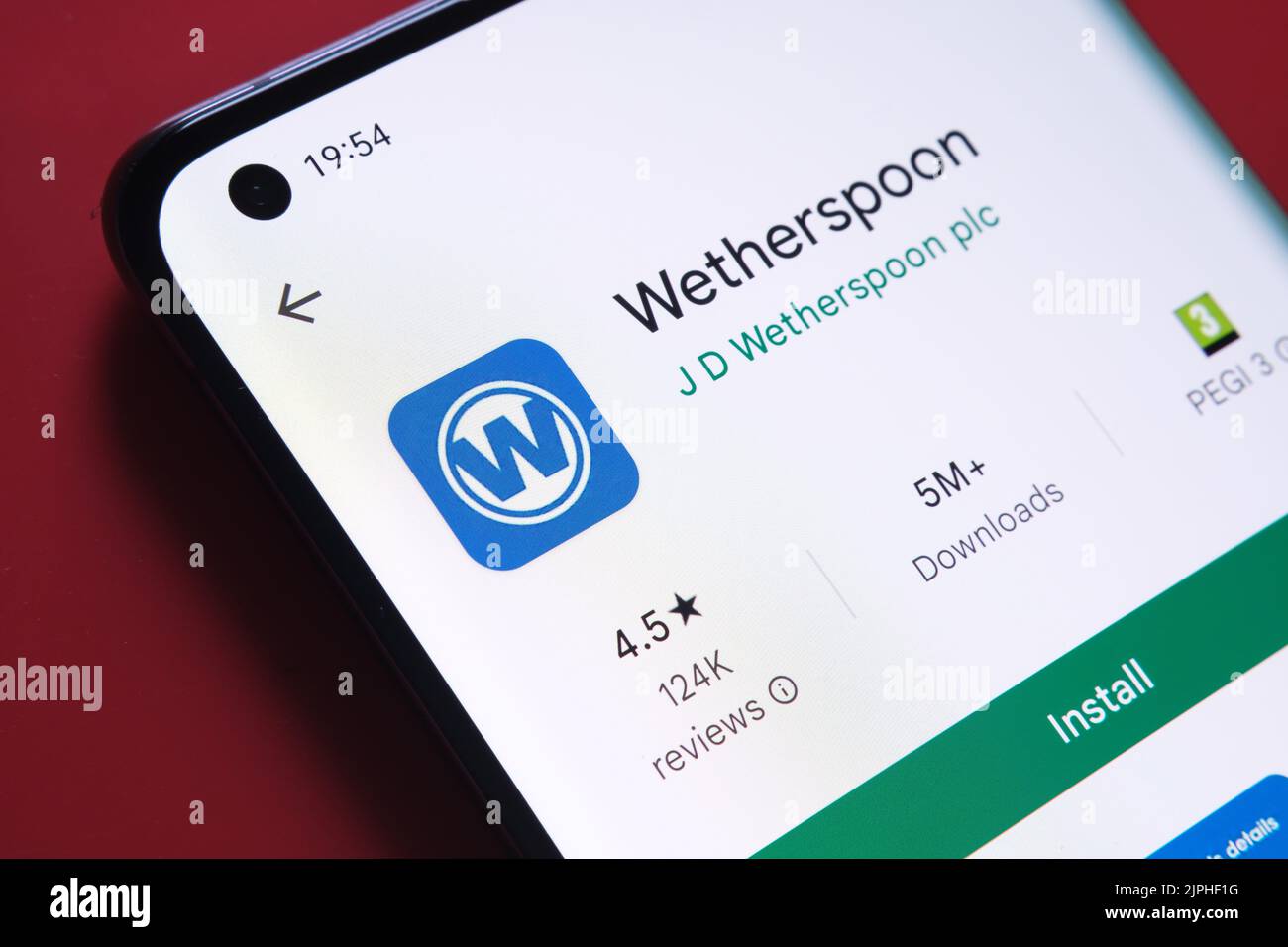 Application Wetherspoon vue dans Google Play Store sur l'écran du smartphone placé sur fond rouge. Gros plan avec mise au point sélective. Stafford, Kin Banque D'Images