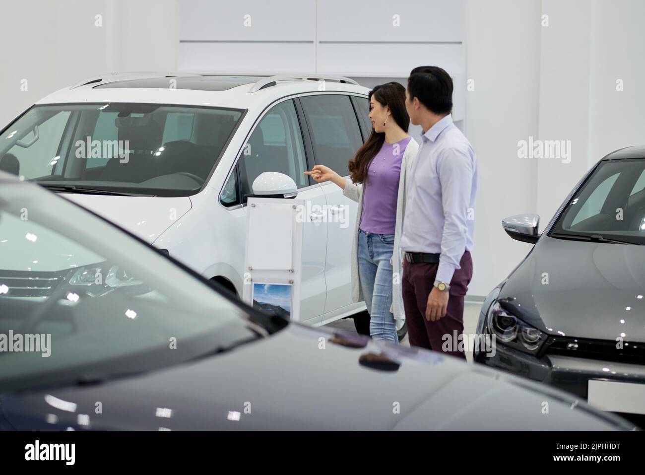 Une jeune femme veut acheter un gros véhicule tout-terrain blanc Banque D'Images