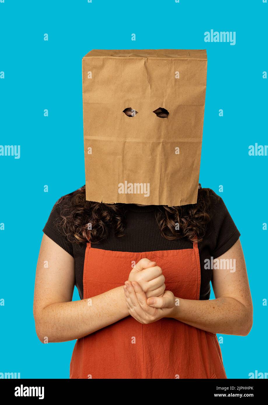 Femme portant un sac en papier sur sa tête tenant son poing Banque D'Images