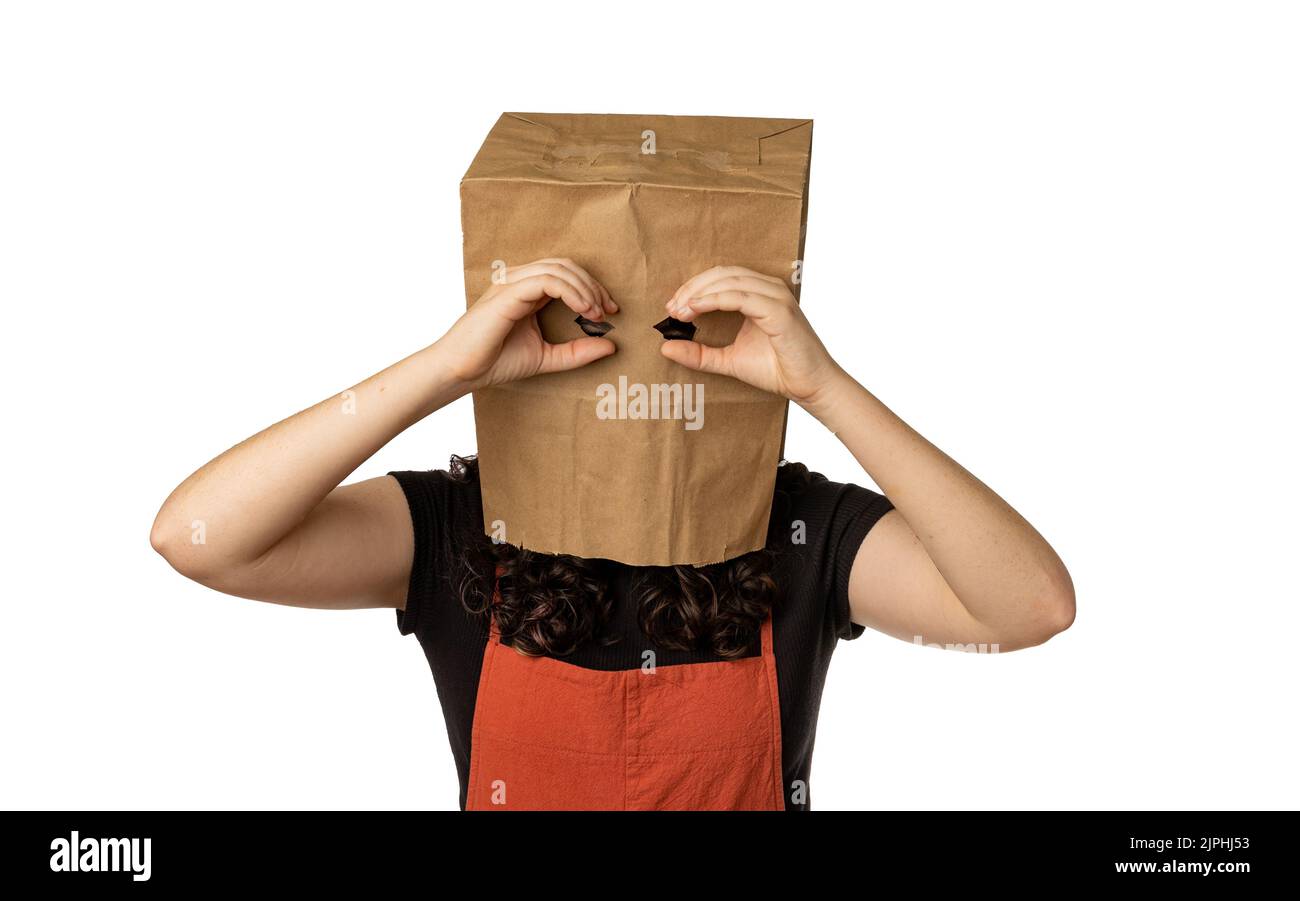 Femme portant un sac en papier au-dessus de sa tête tenant ses mains près des yeux comme des jumelles Banque D'Images