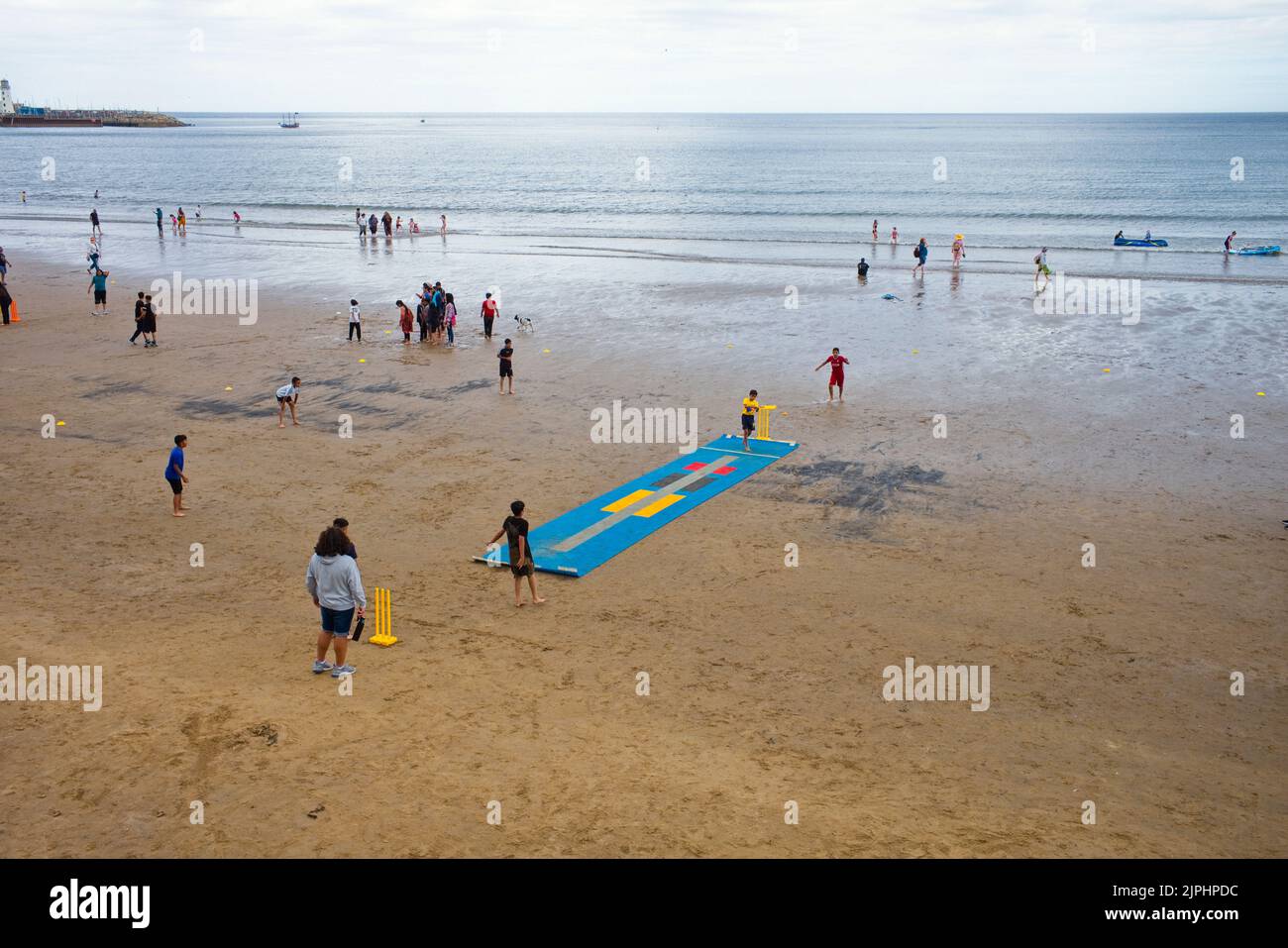 Séances d'entraînement de cricket pour les jeunes garçons asiatiques sur la plage de Scarborough à marée basse Banque D'Images