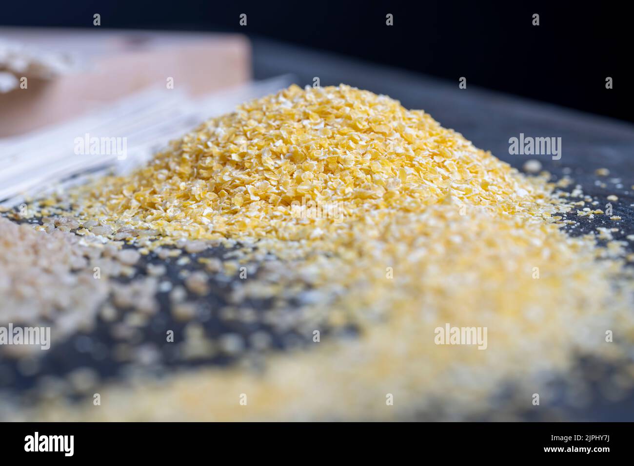 Grains de maïs finement broyés en flocons pour faire du porridge, maïs broyé pour faire un petit déjeuner rapide Banque D'Images
