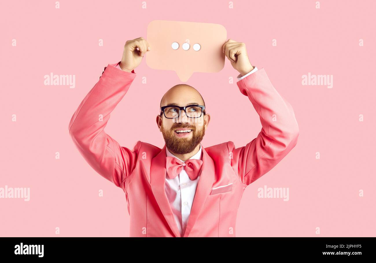 Homme souriant tenir la bulle de la parole avec des points Banque D'Images