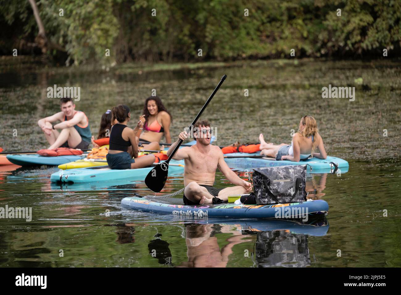 Austin Texas Etats-Unis, 14 août 2022: Les jeunes se détendent sur les paddleboards debout pendant un week-end d'été paresseux après-midi sur le lac Lady Bird près du centre-ville. ©Bob Daemmrich Banque D'Images