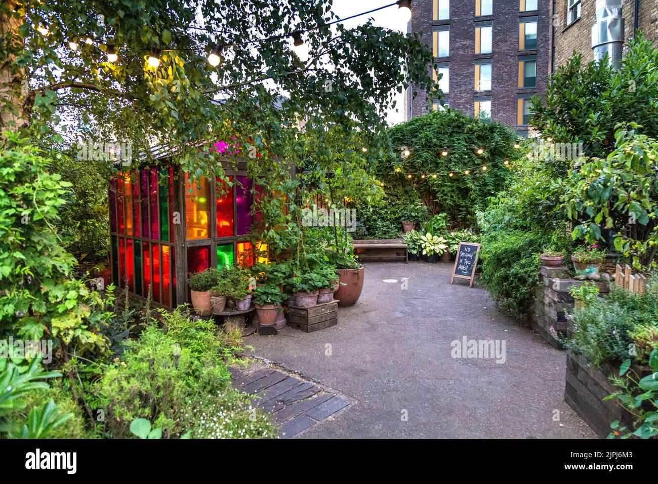 Serre-tête et plantes colorées au café et lieu de musique Dalston Curve Garden, Dalston, Hackney, Londres, Royaume-Uni Banque D'Images