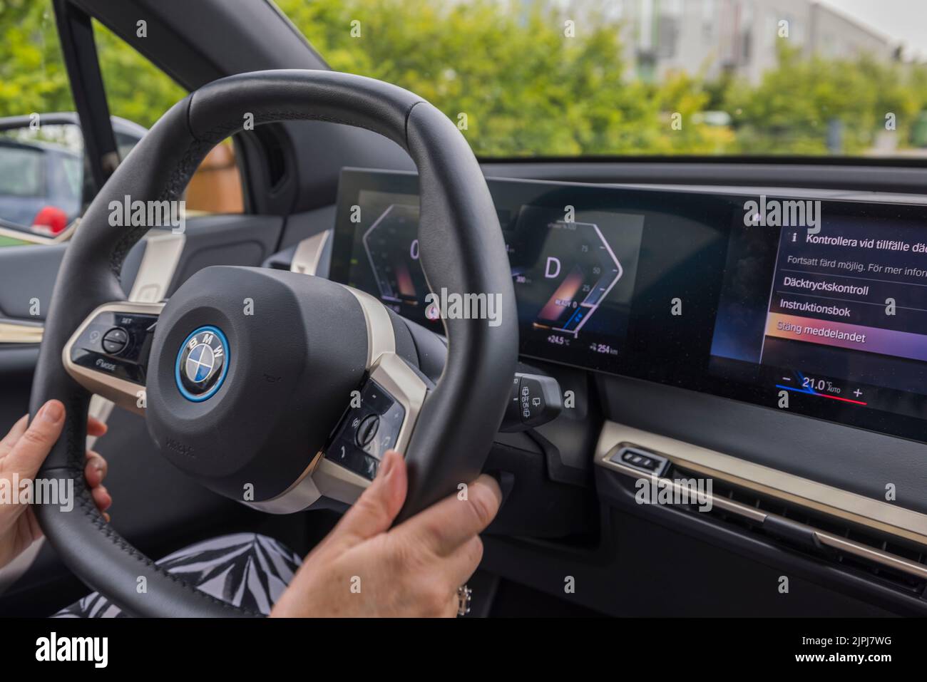Vue rapprochée des mains de femme sur le volant de la nouvelle BMW iX40. Suède. Banque D'Images