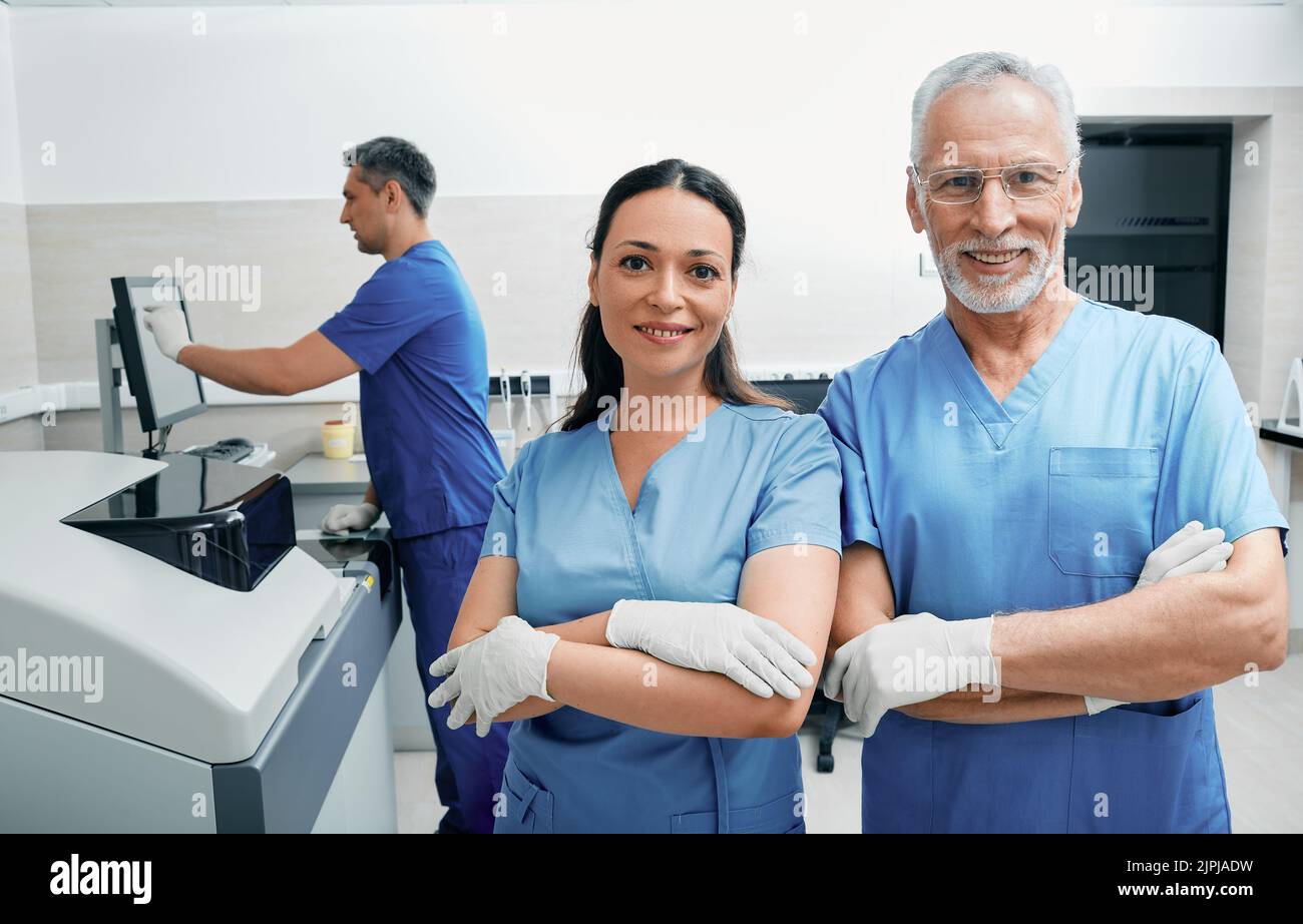 Portrait des travailleurs de laboratoire avec des bras croisés debout en laboratoire médical sur fond de machines et d'équiers modernes de recherche en laboratoire Banque D'Images