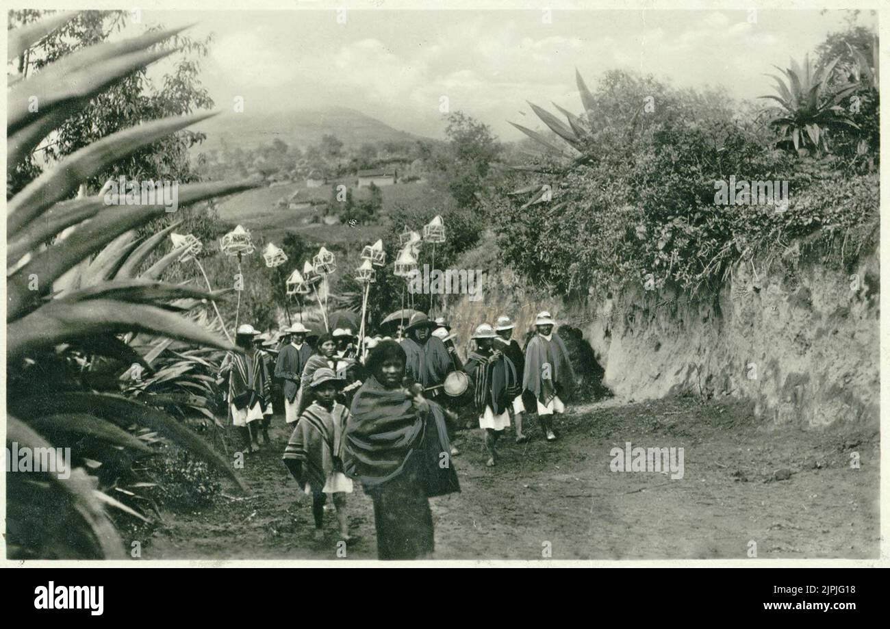 Procession de peuples indigènes marchant vers la masse catholique transportant des lanternes ou des torches sur de longues poteaux en bois, Otavalo, Equateur, Amérique du Sud Banque D'Images