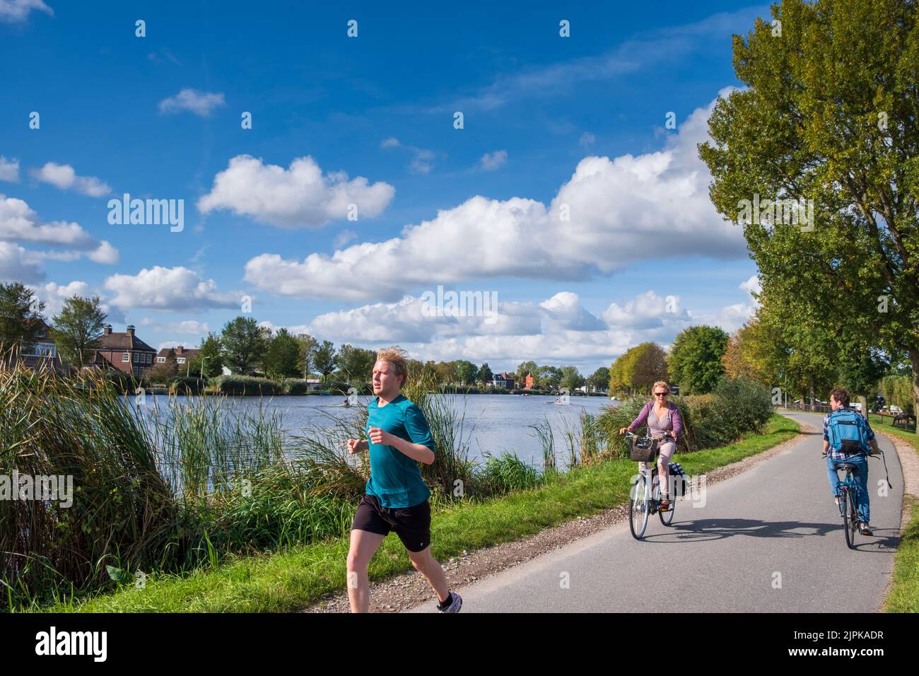 Cycliste et coureurs le long de la rivière Amstel , Amsterdam, pays-Bas Banque D'Images