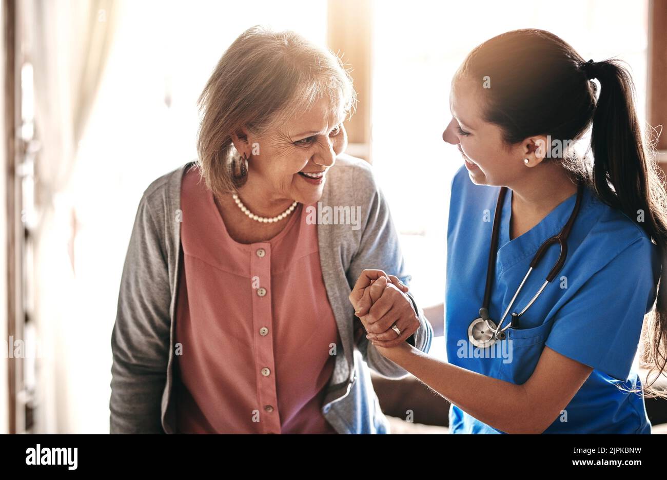 Im ici pour vous aider à chaque étape de la façon. Un soignant aidant un patient âgé dans un foyer de soins infirmiers. Banque D'Images