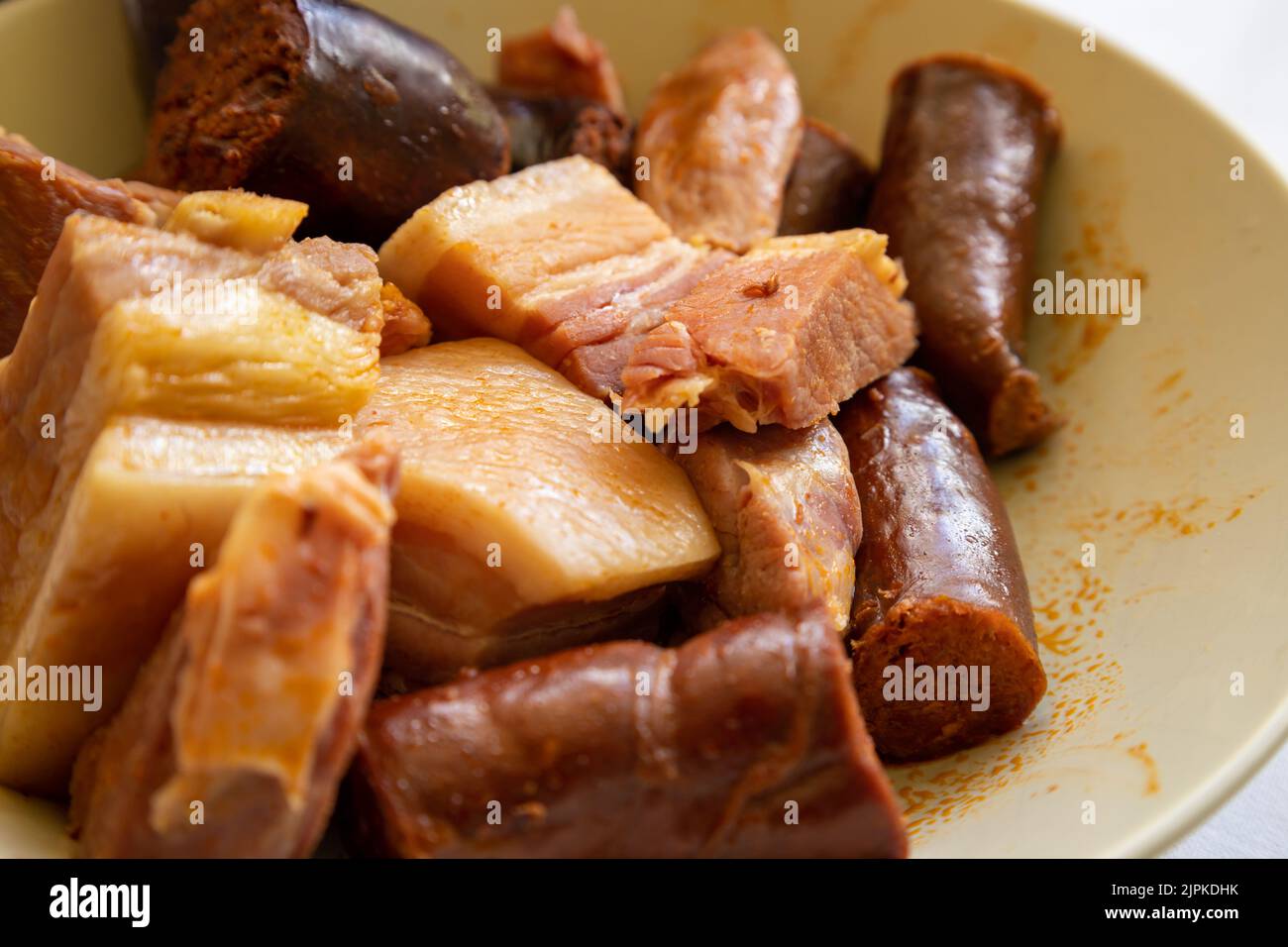 Approche des viandes d'un ragoût de haricots. Cuisine typique des Asturies. Aliments à forte teneur en matières grasses, caloriques et en sodium. Banque D'Images