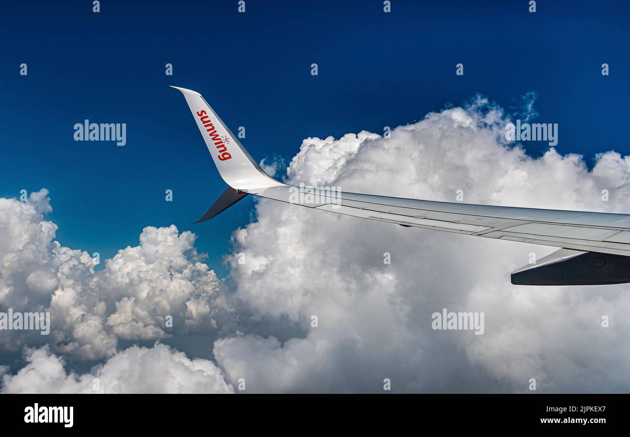 Retour de vacances à Holguin Cuba. Un avion Sunwing survole la côte de Cuba sur fond de nuages lourds au-dessus de l'océan Atlantique. Banque D'Images