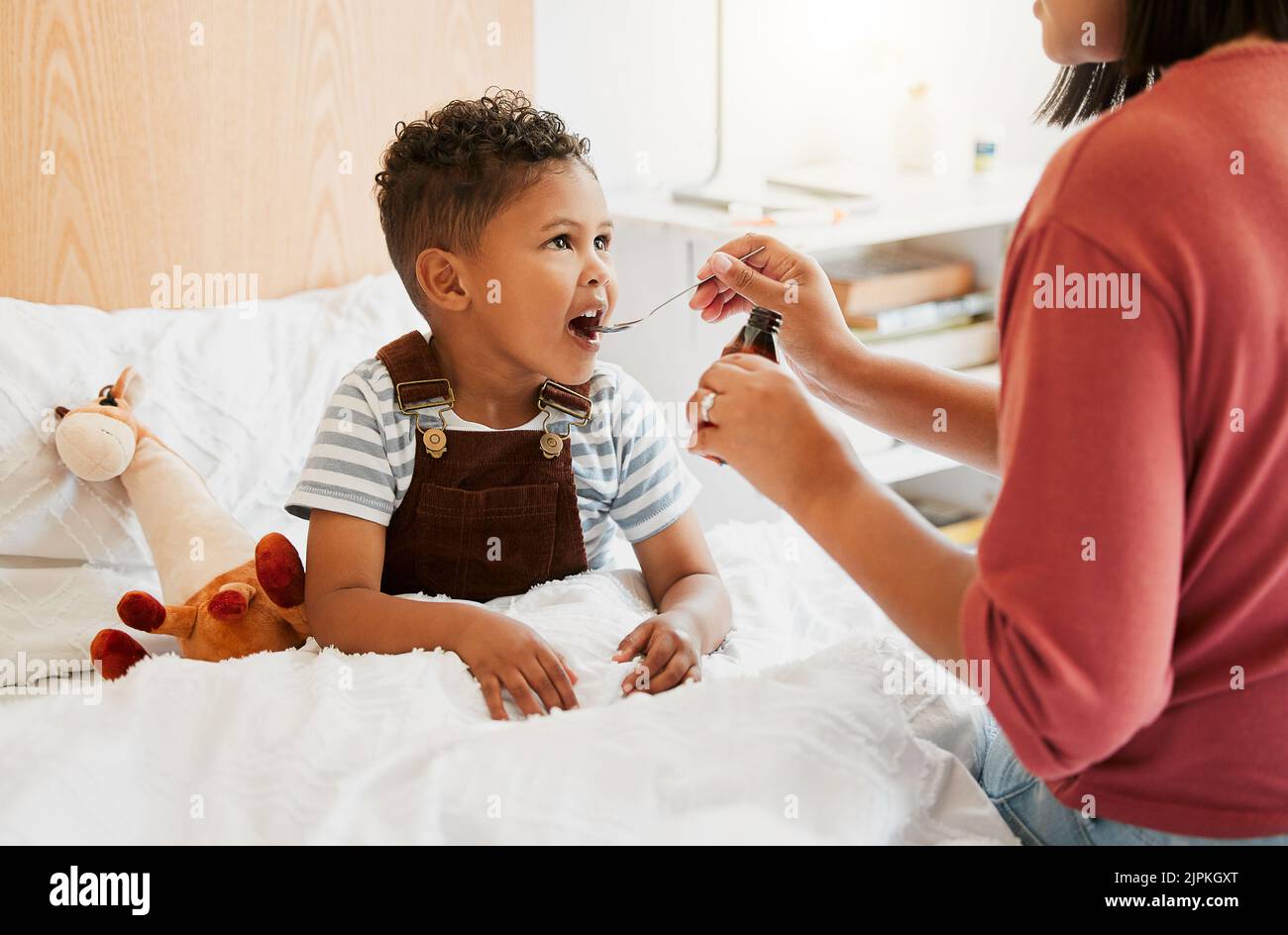 Enfant malade prenant des médicaments sirop, traitement de la grippe et traitement contre le froid pour la maladie, la maladie et les symptômes du virus. Maman prenant soin de la santé de petit fils, enfant et Banque D'Images