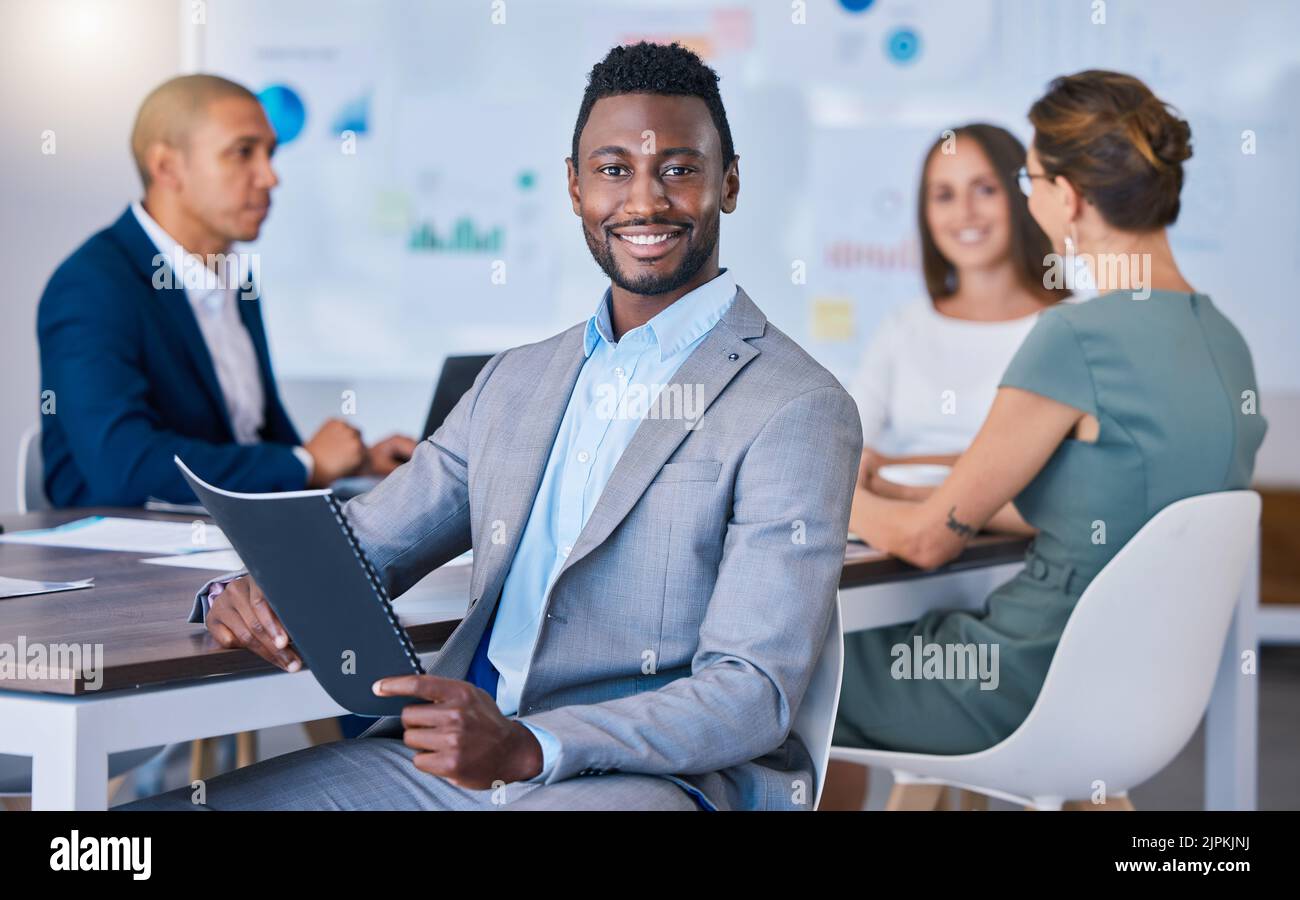 Portrait d'un homme d'affaires confiant dirigeant une réunion dans un bureau moderne, souriant et plein de pouvoir. Joyeux homme noir discutant de stratégies innovantes Banque D'Images