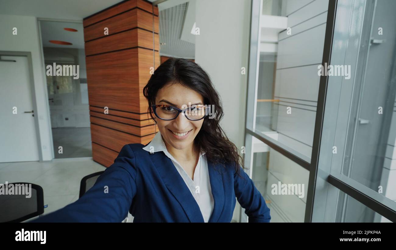 POV de la jeune femme d'affaires en costume prendre un selfie photo tenant un smartphone et s'amuser dans le bureau moderne à l'intérieur Banque D'Images