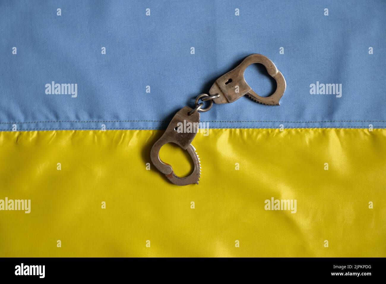 Les menottes se trouvent sur le drapeau jaune-bleu de l'Ukraine, la justice en Ukraine et la loi 2022 Banque D'Images