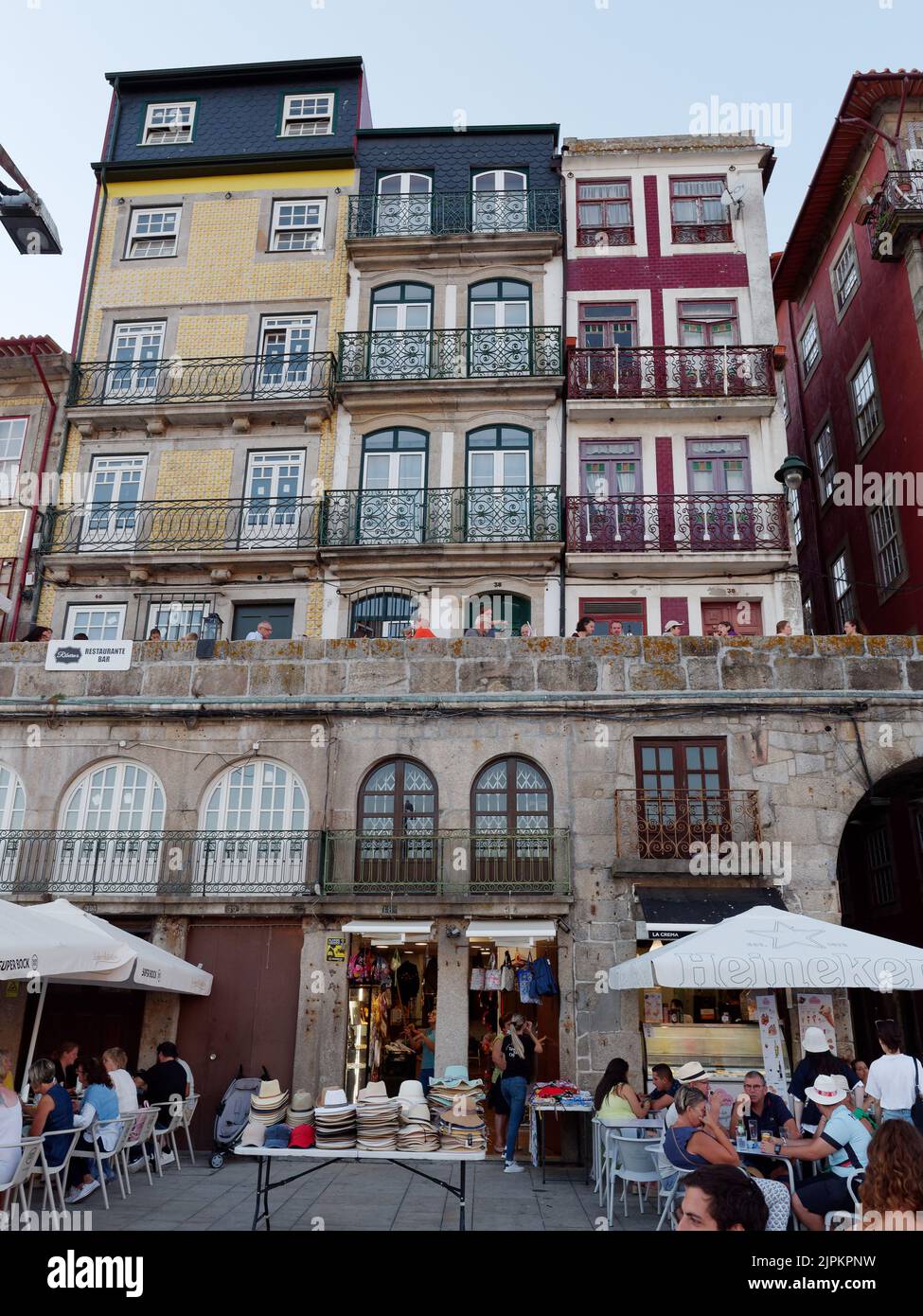 Gros plan sur le quartier Ribeira aka au bord de la rivière avec des maisons traditionnelles colorées avec balcons et petits restaurants et un chapeau au-dessous. Banque D'Images