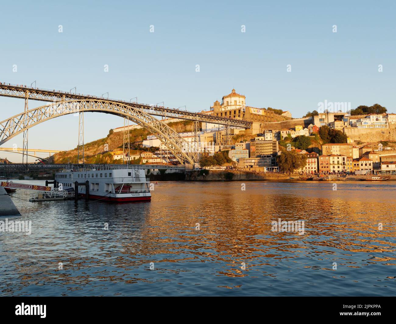 Bateau sur le fleuve Douro à Porto avec le pont Luis I et Vila Nova de Gaia avec le monastère de Serra do Pillar derrière, le soir d'été. Banque D'Images