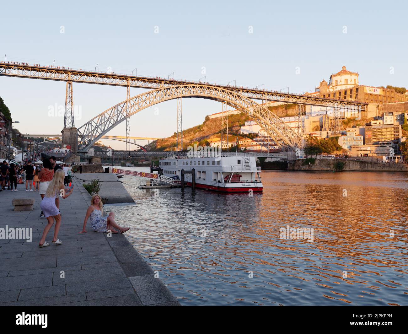 Bateau sur la rivière Duoro à Porto avec le pont Luis I et Vila Nova de Gaia avec le monastère de Serra do Pillar derrière, le soir d'été. Banque D'Images