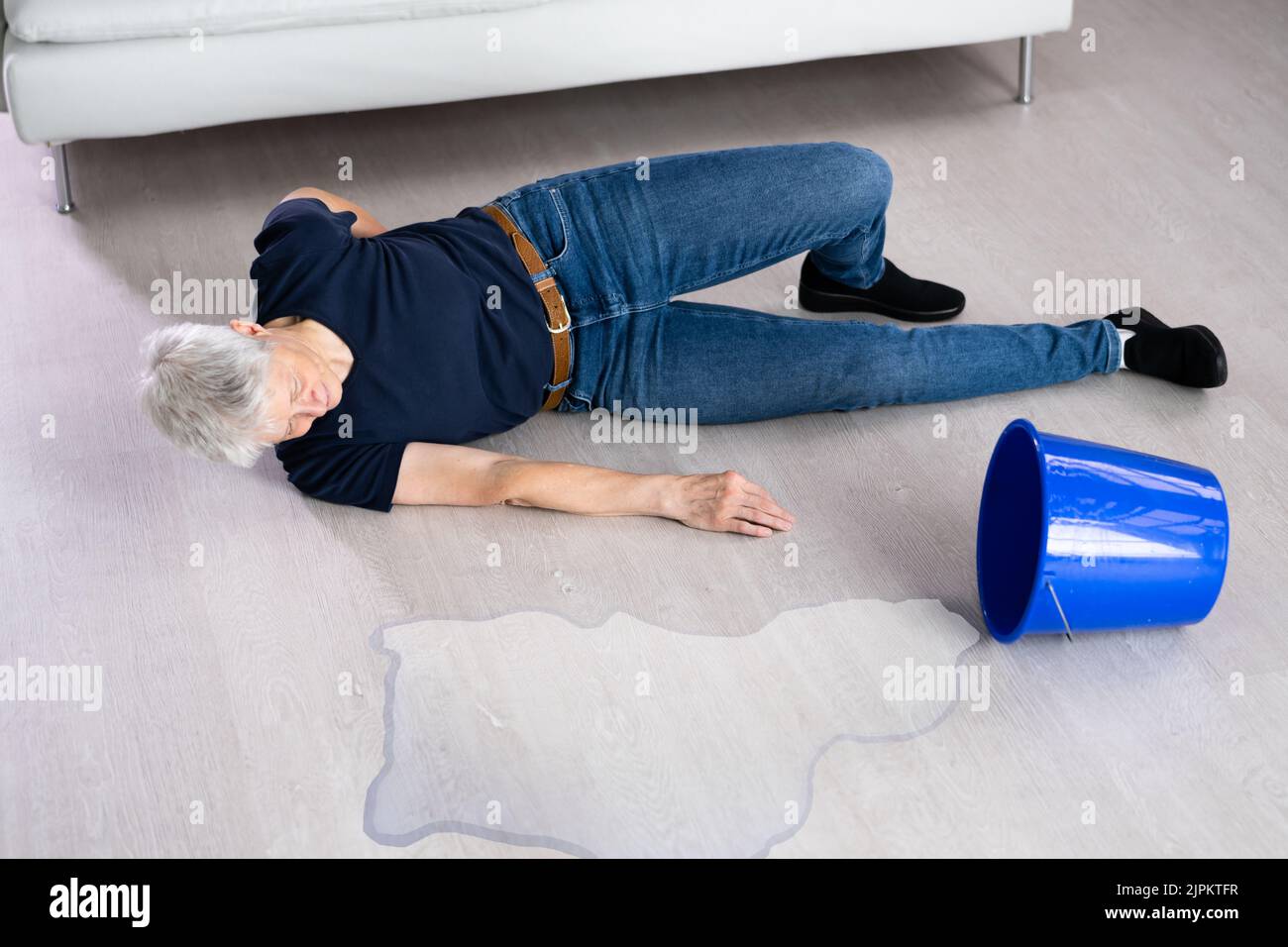 Accident de glissade et de chute. Déversement d'eau sur sol mouillé Banque D'Images