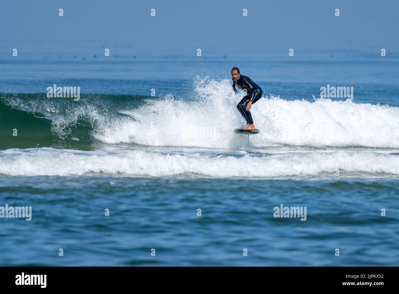 Un homme d'âge moyen faisant du surf en papier ou du surf en hydroglisseur dans la mer, par une journée ensoleillée. Banque D'Images