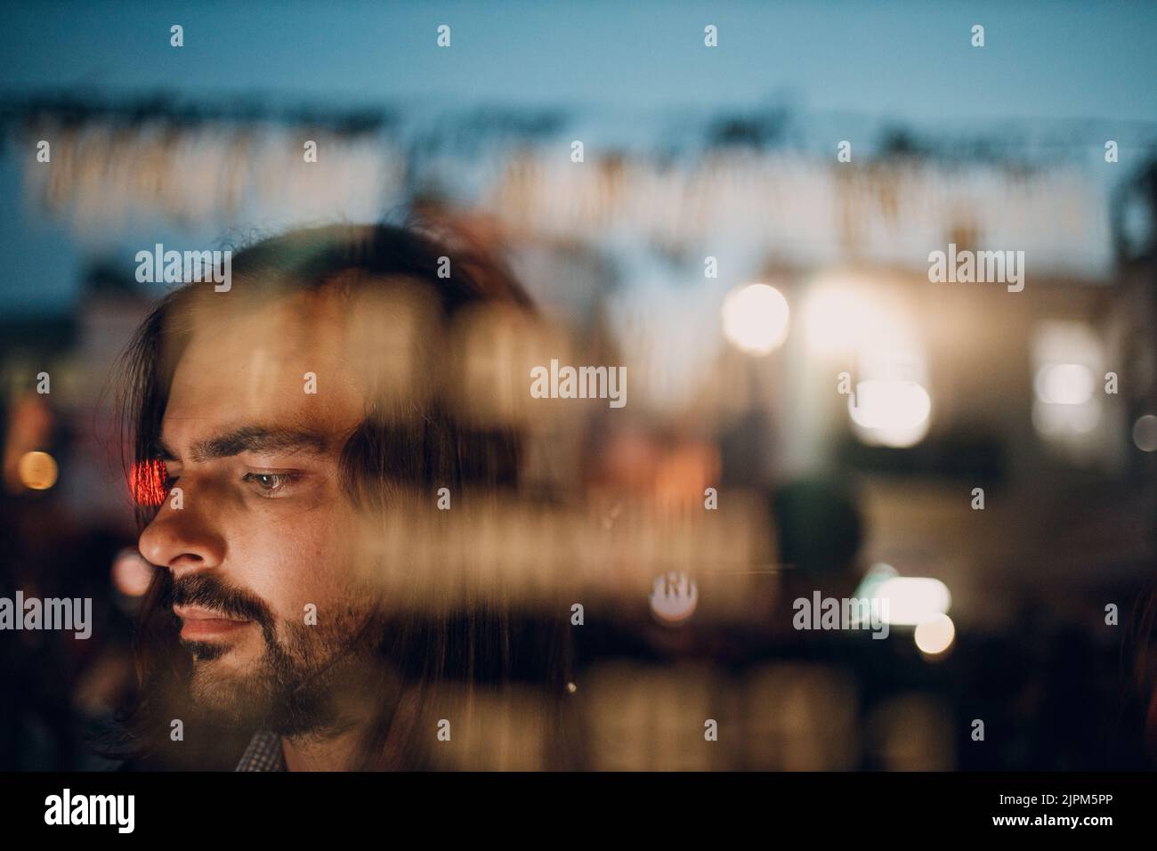 Portrait de nuit profil jeune homme derrière la vitre de porte. Banque D'Images