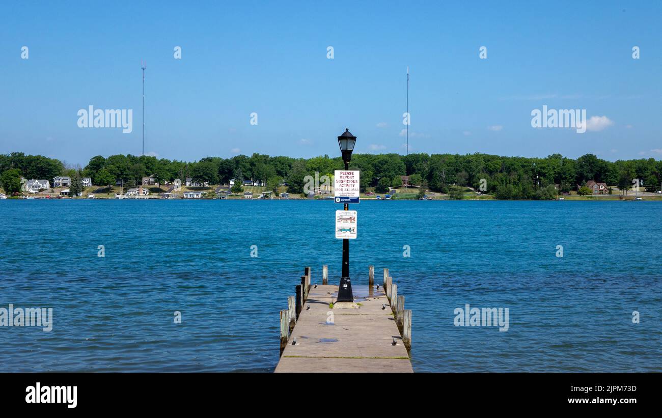 Une vue panoramique d'une borne de lanterne sur une jetée en bois sur un lac par une journée ensoleillée Banque D'Images