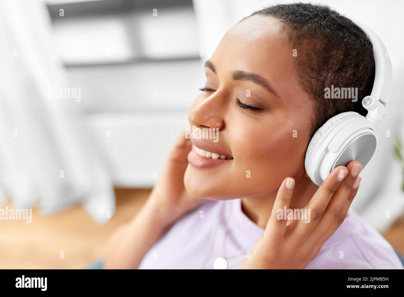 femme dans un casque qui écoute de la musique à la maison Banque D'Images