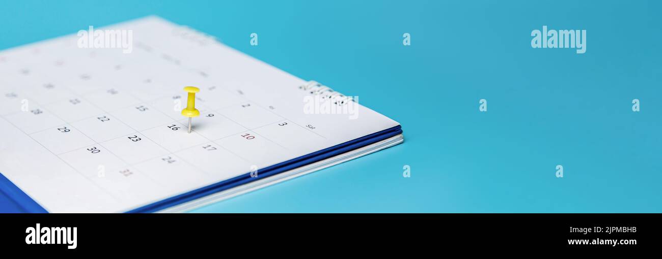 Code PIN jaune sur le calendrier des événements. Calendrier du planificateur sur fond bleu, planifier les réunions d'affaires. Banque D'Images