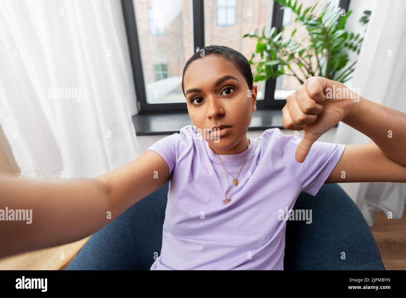 femme prenant le selfie et montrant les pouces vers le bas Banque D'Images